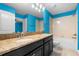 Bright blue bathroom featuring double vanity with granite countertops, a large mirror, and a tub at 8057 John Hancock Dr, Winter Garden, FL 34787