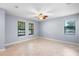 Spacious bedroom with neutral walls, tile floors, ceiling fan and natural light from three windows at 8057 John Hancock Dr, Winter Garden, FL 34787