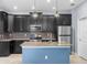 Modern kitchen featuring dark cabinets, stainless steel appliances and an island with sink at 8057 John Hancock Dr, Winter Garden, FL 34787