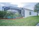Backyard view featuring a screened-in pool and lush greenery, ideal for outdoor relaxation and entertainment at 8100 Fan Palm Way, Kissimmee, FL 34747