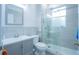Modern bathroom with gray vanity, walk-in shower, and a large mirror at 8100 Fan Palm Way, Kissimmee, FL 34747