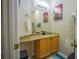 A bathroom with a granite countertop, a sink with a black faucet, and colorful art on the wall at 8100 Fan Palm Way, Kissimmee, FL 34747