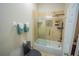 A bathroom with a black toilet, tiled shower with a glass door, and towels on the towel rack at 8100 Fan Palm Way, Kissimmee, FL 34747
