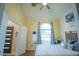 This bedroom has hard wood floors, a ceiling fan, and a bright window with blue curtains at 8100 Fan Palm Way, Kissimmee, FL 34747