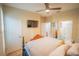 This bedroom features a ceiling fan, tile floors, a television and multiple doors that lead to other areas of the house at 8100 Fan Palm Way, Kissimmee, FL 34747