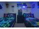 Bedroom featuring two beds, neon lighting, and gaming theme at 8100 Fan Palm Way, Kissimmee, FL 34747