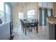 Bright dining area featuring a dark wood table with seating for six and large windows at 8100 Fan Palm Way, Kissimmee, FL 34747