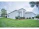 Side view of a white single-Gathering home with well-manicured lawn and minimal landscaping; providing a serene, private atmosphere at 8100 Fan Palm Way, Kissimmee, FL 34747