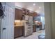 Kitchen with brown cabinets, stainless steel appliances, granite countertops and white tiled floors at 8100 Fan Palm Way, Kissimmee, FL 34747