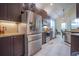 Kitchen with granite countertops, stainless steel appliances, brown wood cabinets and white tiled floors at 8100 Fan Palm Way, Kissimmee, FL 34747