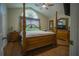 Main bedroom featuring hardwood floors, ceiling fan, and large bed at 8100 Fan Palm Way, Kissimmee, FL 34747