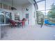 A covered outdoor patio features a dining set and lounge chair, perfect for relaxation at 8100 Fan Palm Way, Kissimmee, FL 34747