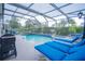 Screened-in pool and spa area with ample seating for entertaining and lush surroundings at 8100 Fan Palm Way, Kissimmee, FL 34747