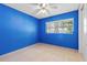 Simple bedroom features a ceiling fan, and a bright blue accent wall at 9014 Great Sound Dr, Orlando, FL 32827
