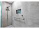 Modern tiled shower featuring a rainfall showerhead, niche and a safety grab bar at 9014 Great Sound Dr, Orlando, FL 32827
