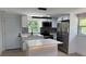Renovated kitchen with stainless steel appliances, island with bar seating, and granite countertops at 1011 W 16Th St, Sanford, FL 32771