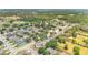 An aerial view shows a residential neighborhood with mature trees near a school, park, and small lake at 10984 Pinewood Cove Ln, Orlando, FL 32817