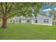Beautiful backyard showcasing a well-maintained lawn, mature trees, and a home with a patio at 10984 Pinewood Cove Ln, Orlando, FL 32817