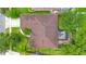 A detailed aerial view of the roof and screened-in patio of a home with mature landscaping at 1107 Carringdale Dr, Orlando, FL 32828