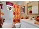 Full bath features a shower-tub combo and a bright floral shower curtain at 1107 Carringdale Dr, Orlando, FL 32828