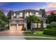 Stunning two-story home featuring a well-manicured lawn, three-car garage, and charming architectural details at 12530 Climbing Vine Ct, Windermere, FL 34786