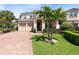 Charming home with a brick driveway, lush lawn, and a neatly landscaped garden with a palm tree at 12530 Climbing Vine Ct, Windermere, FL 34786