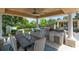 Covered outdoor kitchen and dining area complete with built in grill, refrigerator, countertop space and large dining table at 12530 Climbing Vine Ct, Windermere, FL 34786