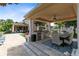 Covered outdoor kitchen and dining area complete with stainless steel grill, travertine tile and bar stool seating at 12530 Climbing Vine Ct, Windermere, FL 34786