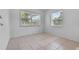 Bright bedroom featuring neutral tile floors and natural light from two windows at 1330 Lakeview Rd, Lake Wales, FL 33853