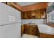 Functional kitchen features wooden cabinets, white appliances, and a clean layout, perfect for cooking at 1330 Lakeview Rd, Lake Wales, FL 33853