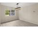 The dining room has light wood floors and white walls and features a window with exterior views and modern lighting at 15690 Sw 46Th Cir, Ocala, FL 34473