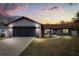 A beautifully renovated single Gathering home featuring a gray exterior, with stone accents and a two-car garage at 15690 Sw 46Th Cir, Ocala, FL 34473