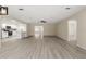 An open concept living room with light hardwood floors flows into the updated white kitchen with stainless appliances at 15690 Sw 46Th Cir, Ocala, FL 34473
