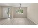 The living room has light wood floors and white walls, features a window and a door with exterior views and modern lighting at 15690 Sw 46Th Cir, Ocala, FL 34473