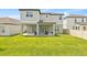 Rear exterior of a two-story home with covered patio, grill, and backyard seating at 16013 Silver Brook Way Way, Winter Garden, FL 34787