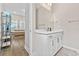 Modern bathroom with white vanity, large mirror, and neutral walls at 16013 Silver Brook Way Way, Winter Garden, FL 34787