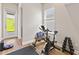 Home gym with weights, exercise bicycle, wood floors, and sliding door leading to green space at 16013 Silver Brook Way Way, Winter Garden, FL 34787