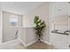 Upstairs hallway with indoor potted tree and doorway to a carpeted bedroom at 16013 Silver Brook Way Way, Winter Garden, FL 34787