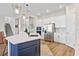 Contemporary kitchen featuring a large island, stainless steel appliances, white cabinetry, and hardwood floors at 16013 Silver Brook Way Way, Winter Garden, FL 34787