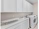 Well-equipped laundry room featuring ample storage, modern washer and dryer, and convenient folding area at 16013 Silver Brook Way Way, Winter Garden, FL 34787