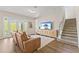 Bright living room with stairs, a large television and doors leading to the backyard at 16013 Silver Brook Way Way, Winter Garden, FL 34787