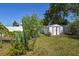 Backyard featuring a shed, cactus, and plenty of foliage at 1732 Oasis Ave, Deltona, FL 32725