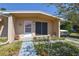 Close-up of the front entrance with a covered porch and minimalist landscaping at 1732 Oasis Ave, Deltona, FL 32725