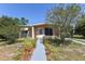 Charming single-story home with a walkway lined with beautiful plants and trees at 1732 Oasis Ave, Deltona, FL 32725
