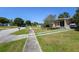 Quiet residential street view of a modest home featuring sidewalk access at 1732 Oasis Ave, Deltona, FL 32725