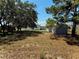View of the sheds in the large backyard with mature trees at 204 Holland St, Lake Wales, FL 33859