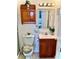 Cozy bathroom with wooden vanity, toilet, and decorative mirror with matching cabinet at 204 Holland St, Lake Wales, FL 33859