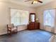 Bright bedroom with a ceiling fan, dresser with mirror, and windows with lace curtains at 204 Holland St, Lake Wales, FL 33859