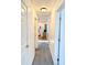 Hallway leading to kitchen with grey carpet and white doors at 204 Holland St, Lake Wales, FL 33859