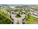 Aerial view of a neighborhood roundabout with landscaping and water view in the background at 2130 Bur Oak Blvd, St Cloud, FL 34771
